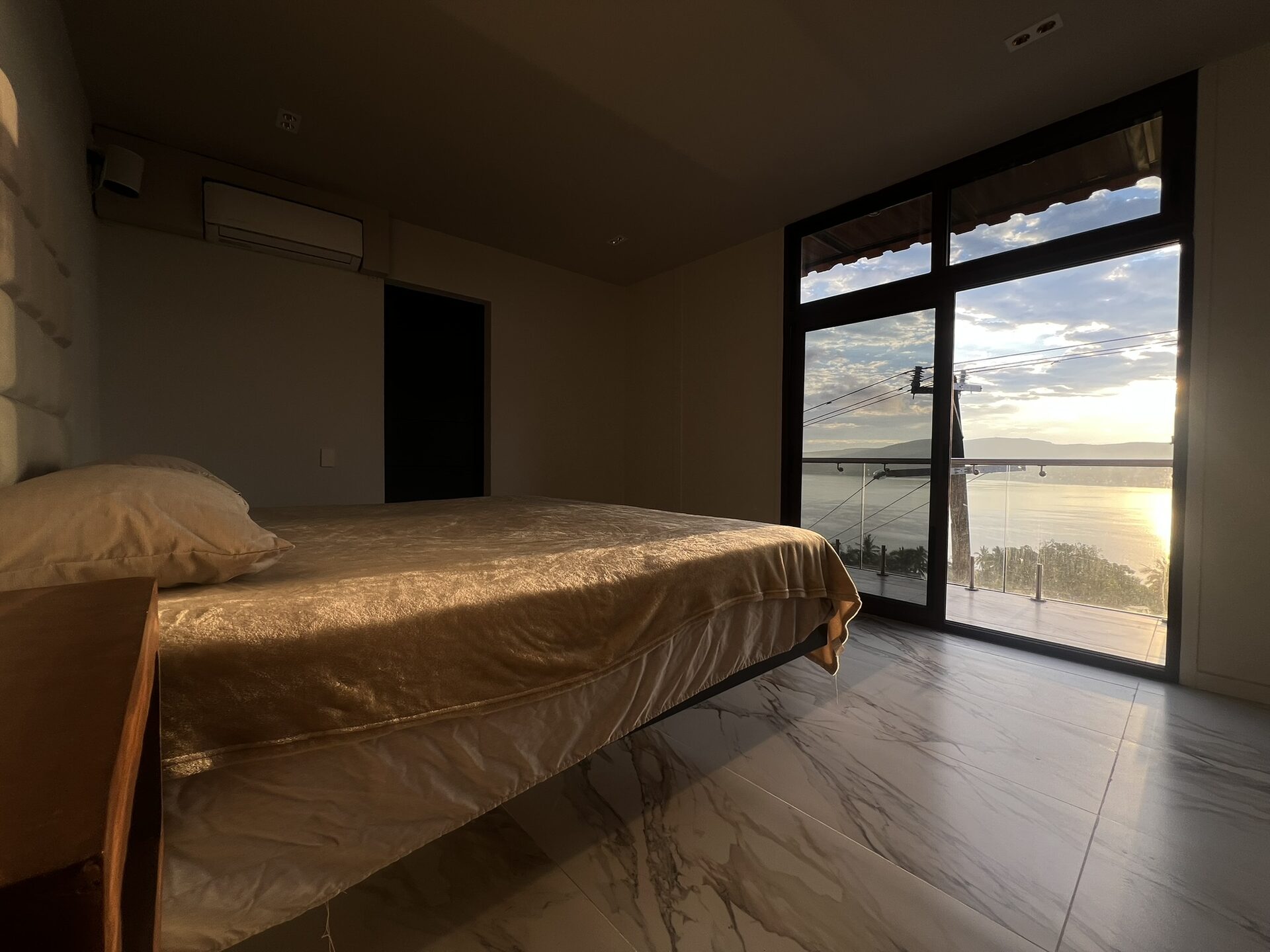 Master suite con cama king size y vista panorámica al lago de Tequesquitengo al atardecer — Casa Boutique Vista Lago